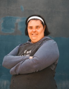 foto de Marta Pérez, artista del Arte de Vivir, sonriendo y llevando un delantal con el logo del taller inclusivo.