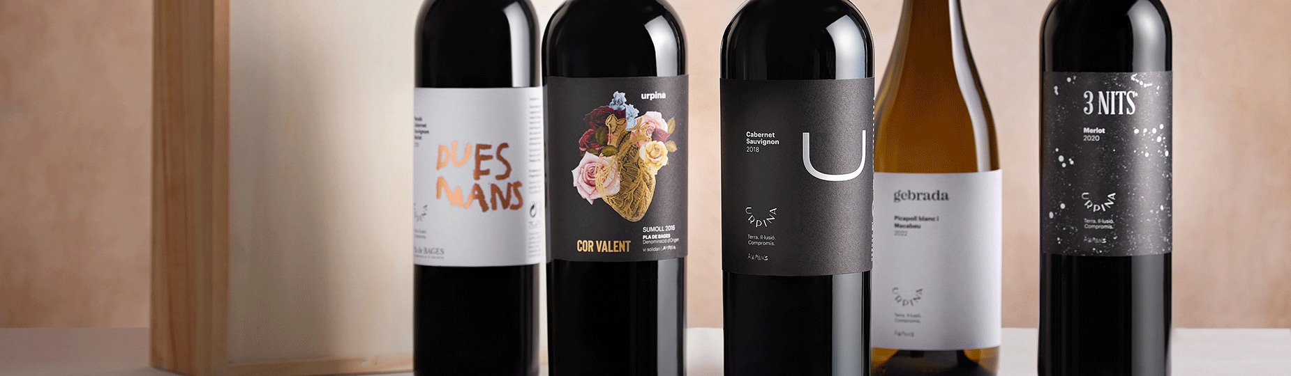 Botellas de vinos Urpina de AMPANS y viñedo ecológico en el Bages, representando la calidad y sostenibilidad de sus productos solidarios